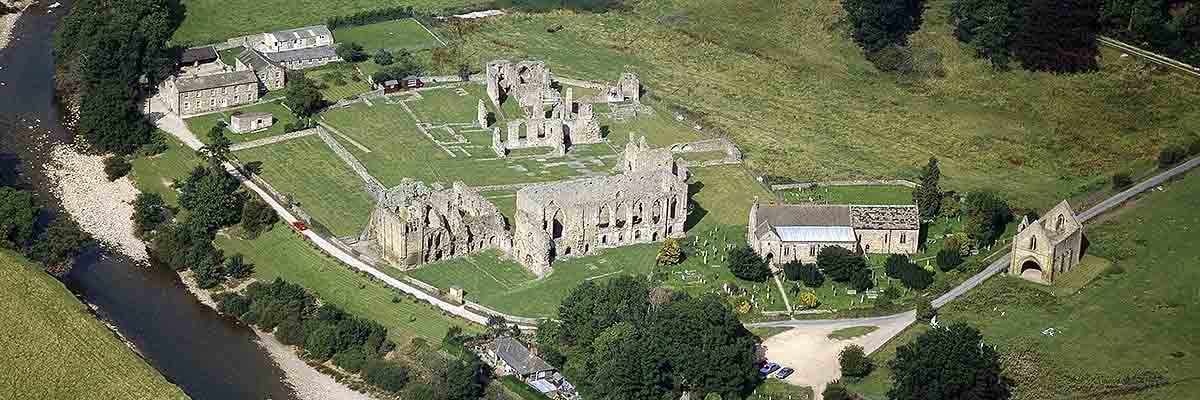 Aerial view of Easby Abbey and the river Swale from the south-west. The church of St Agatha is visible on the right