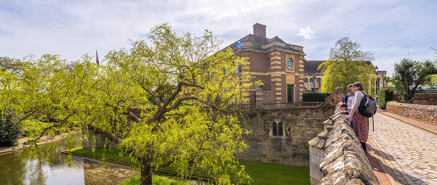 Visitors looking across the moat at Eltham Palace