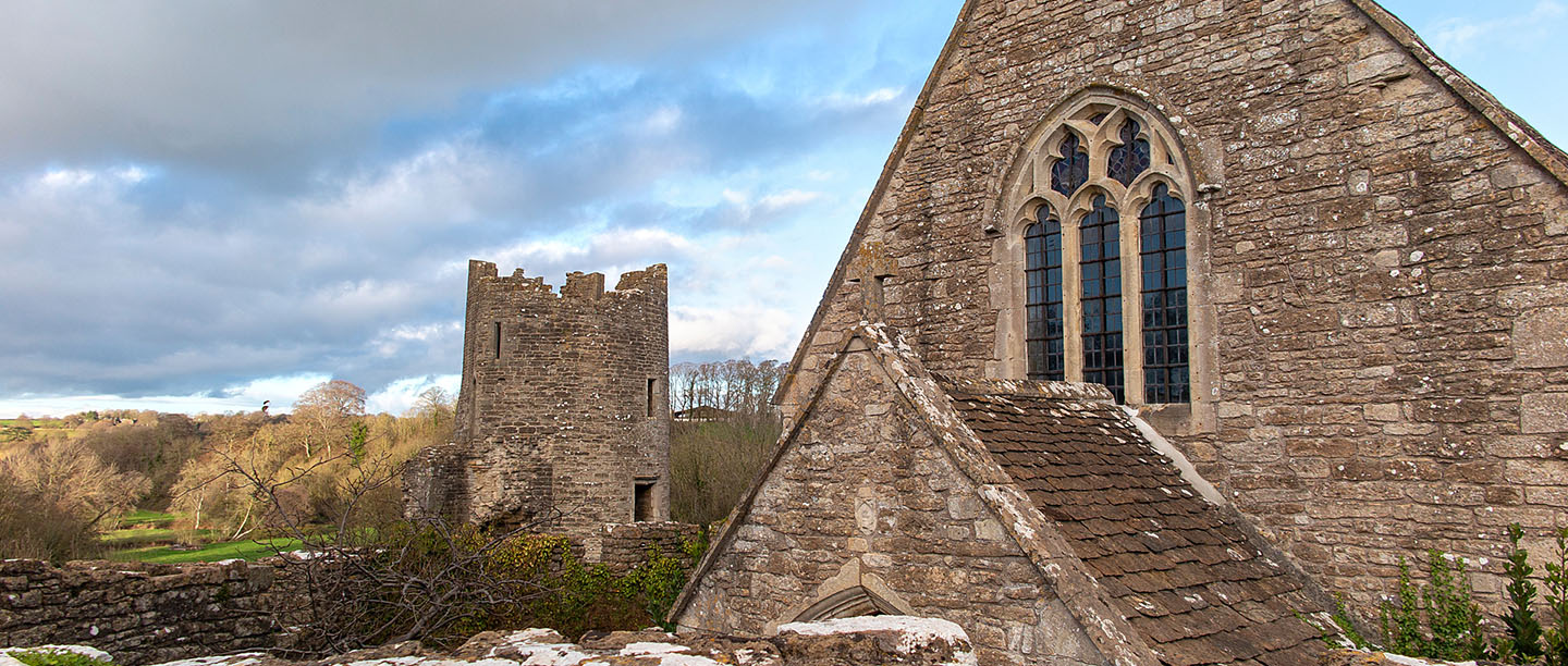 The chapel window at Farleigh Hungerford Castle with tower ruins in the background