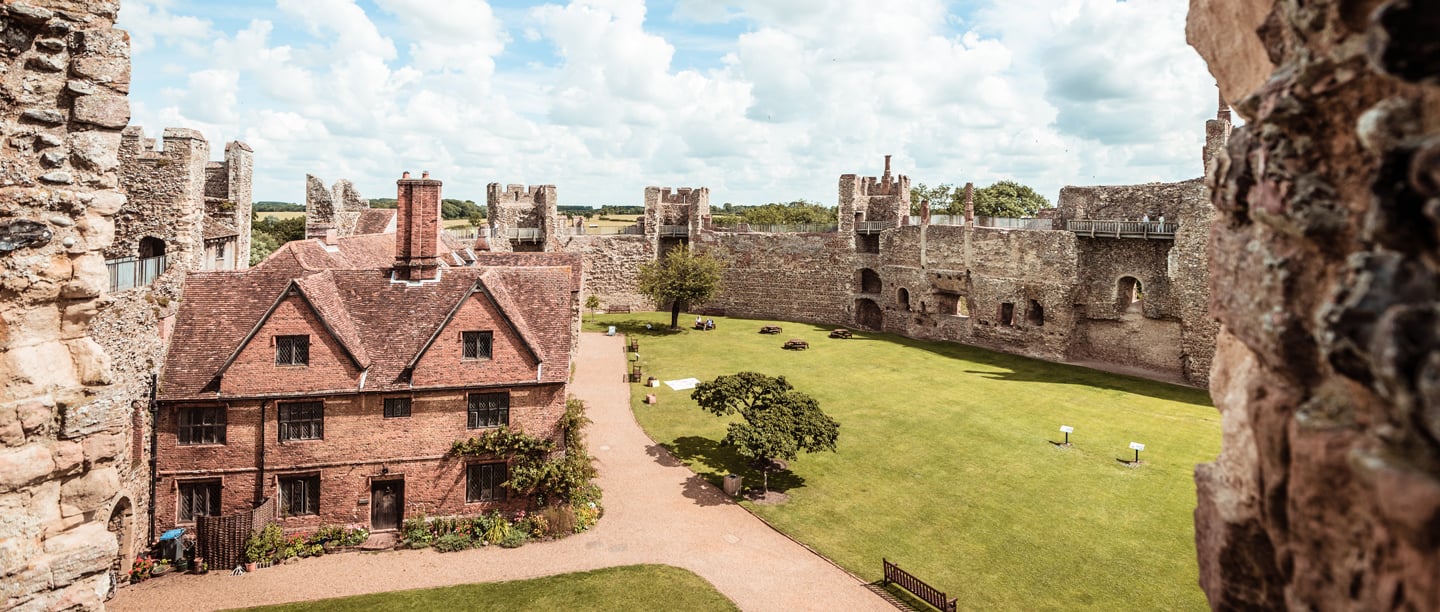 A view of the brick workhouses and Framlingham Castle from the walls on a cloudy day.