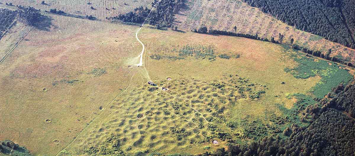 Grime’s Graves seen from the south. The dry valley to the north of the site at one time contained a stream or river, which would have been the nearest water supply for the Neolithic miners Grime’s Graves seen from the south. The dry valley to the north of the site at one time contained a stream or river, which would have been the nearest water supply for the Neolithic miners
