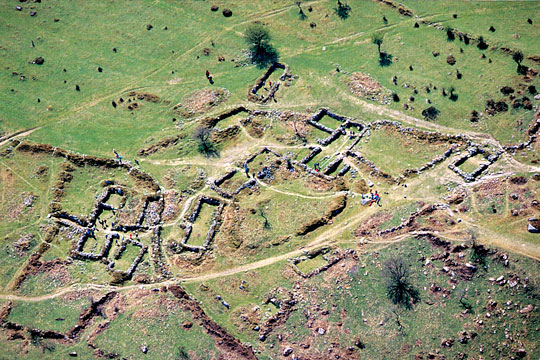 Aerial view of Hound Tor from the north with visitors investigating the remains