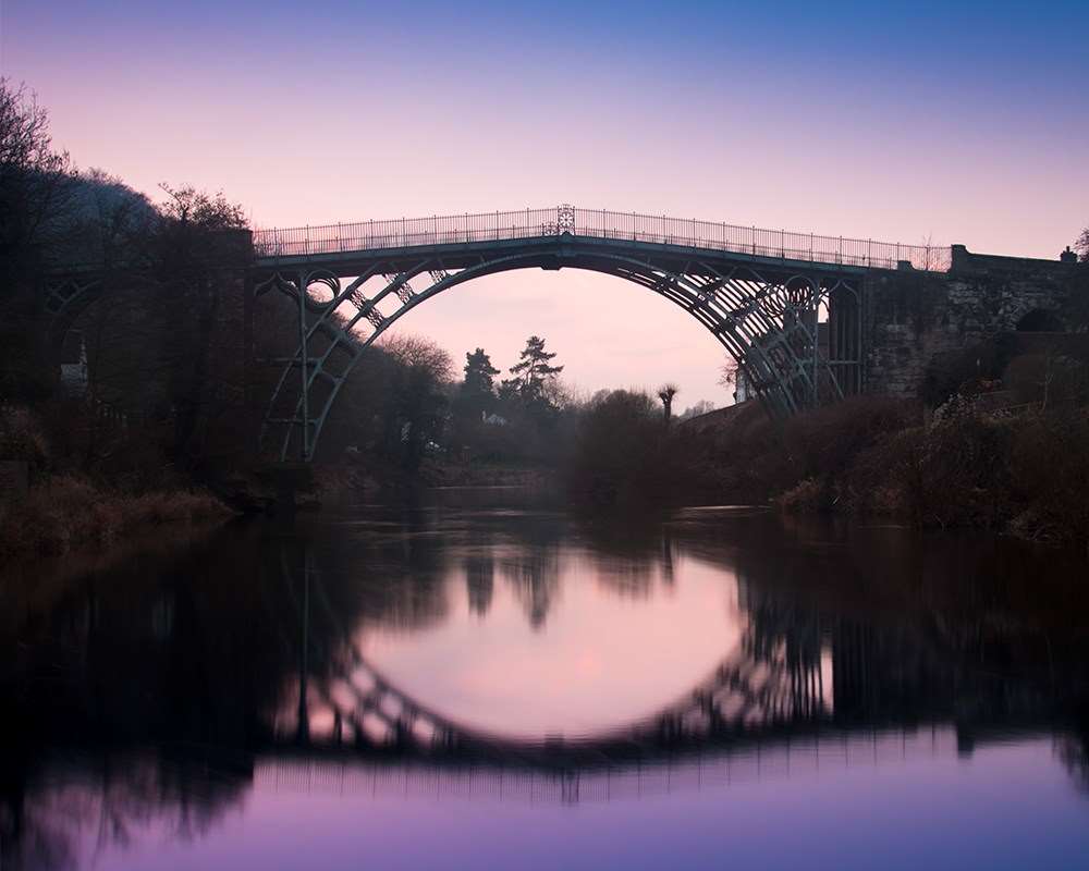 The Iron Bridge at night against a purple sky 