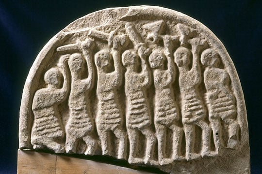 The 9th-century grave marker found at Lindisfarne Priory, known as the Viking Domesday stone, carved on this side with seven armed men brandishing weapons