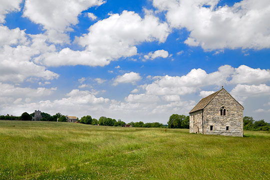 The Fish House in its idyllic landscape setting with cumulus clouds in a bright blue sky