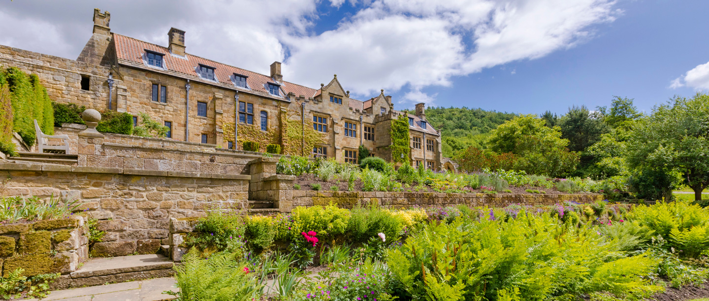 A view of the exterior of he gardens at Mount Grace Priory and the building behind.