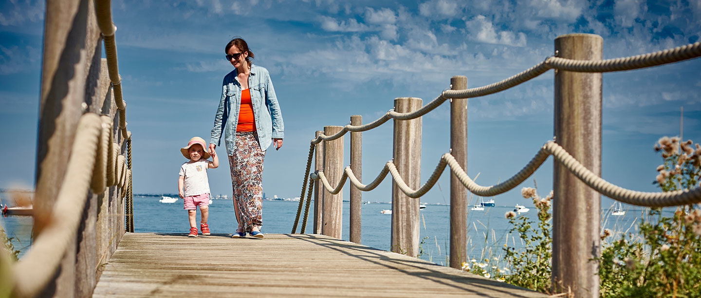 A parent and child walking on the beach at Osborne