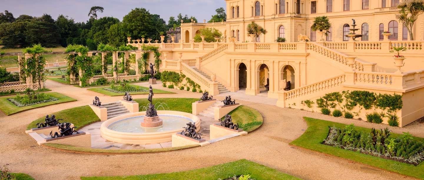 The terraces of Osborne House, peach in colour, with planted gardens and a fountain