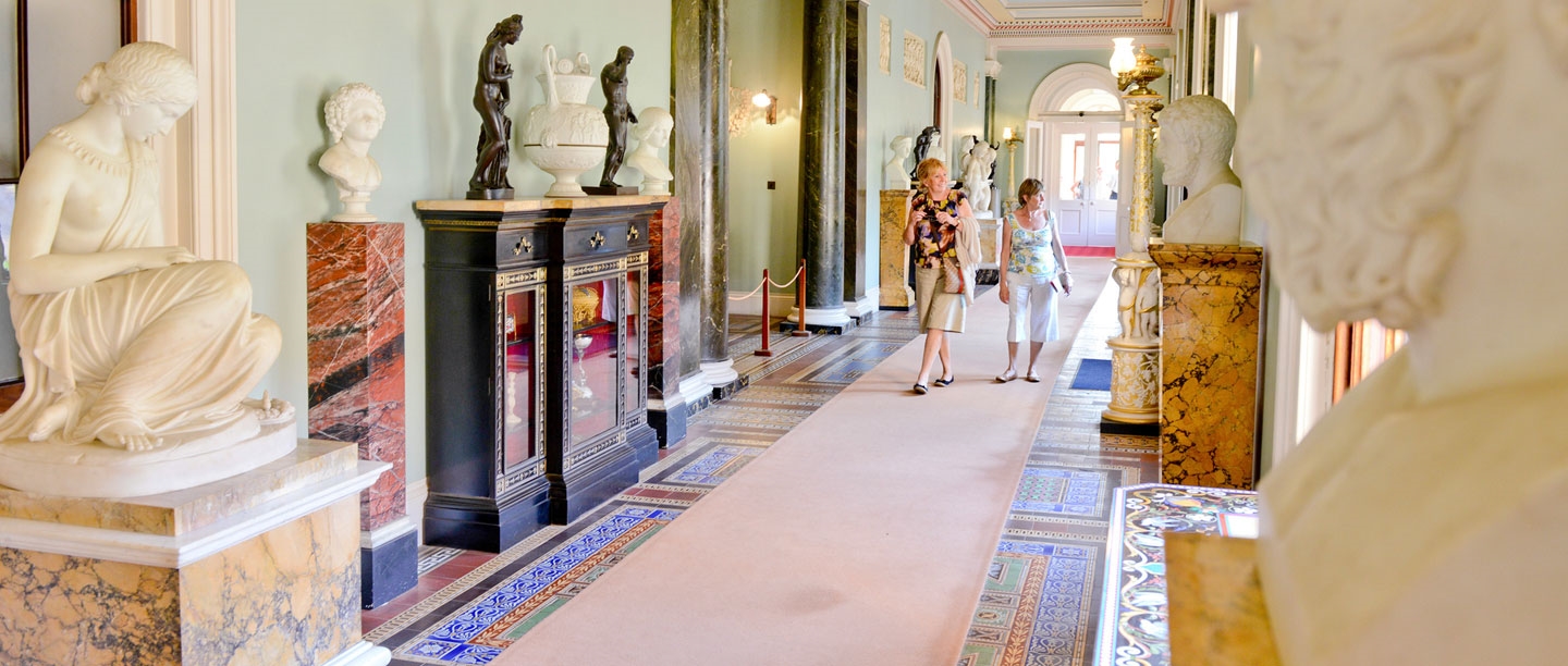 Two people walk through a corridor at Osborne