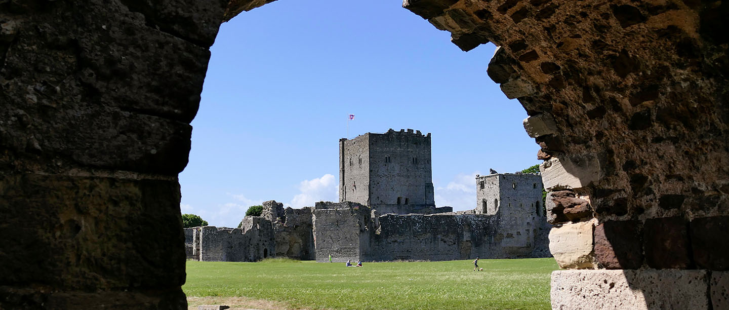 Portchester Castle keep viewed through a stone arch
