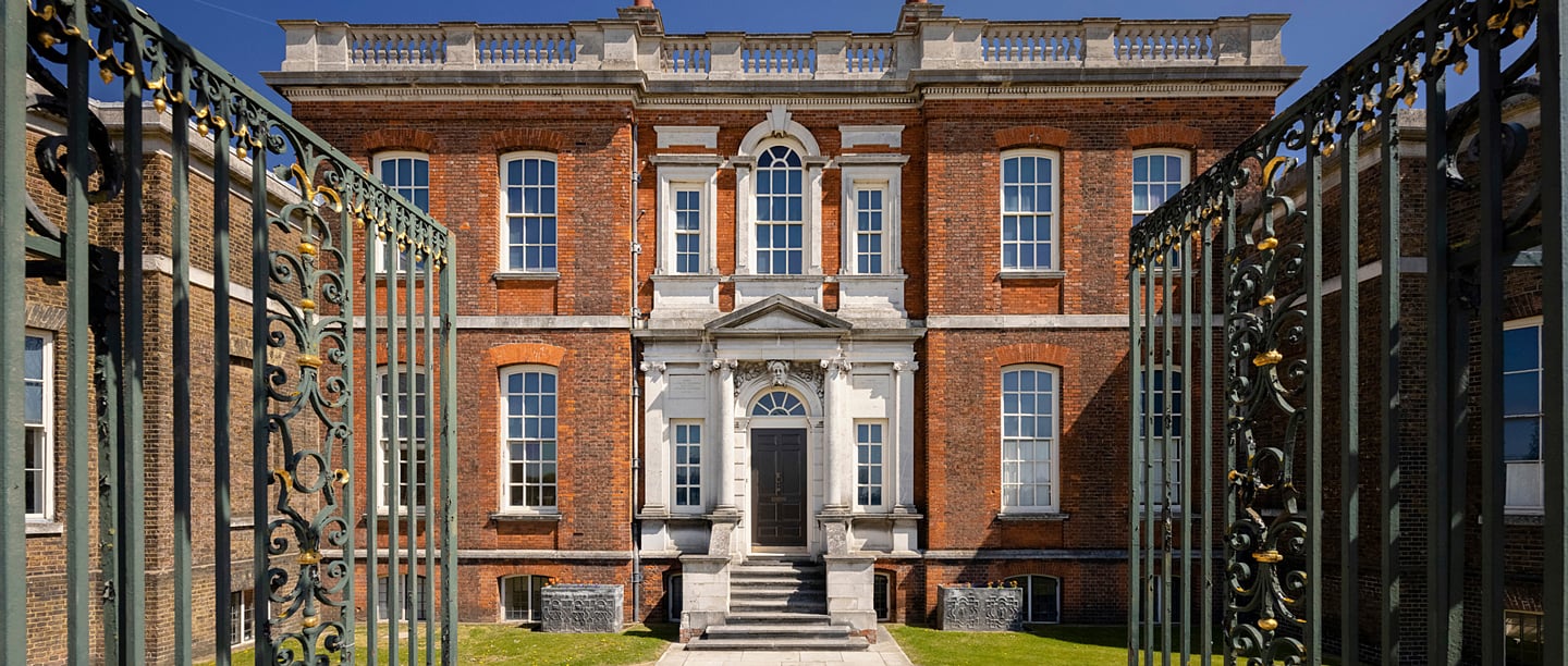 The facade of Ranger's House viewed through open iron gates.