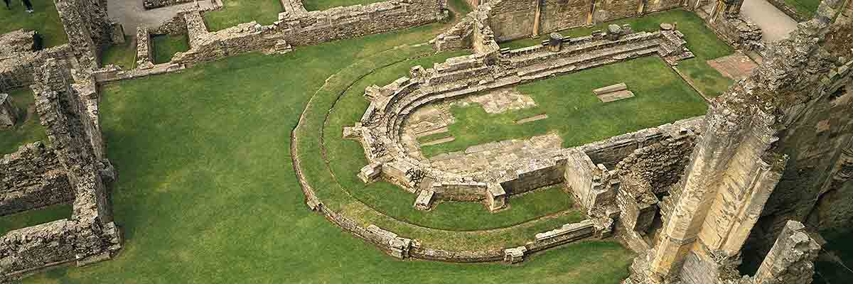 Aerial view of the remains of the chapter house at Rievaulx Abbey – its unusual rounded east end makes it one of the most remarkable buildings from Abbot Aelred’s rule Aerial view of the remains of the chapter house at Rievaulx Abbey – its unusual rounded east end makes it one of the most remarkable buildings from Abbot Aelred’s rule