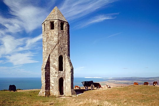 St Catherines Oratory with cattle grazing round and about wnd the sea below in the background St Catherines Oratory with cattle grazing round and about wnd the sea below in the background