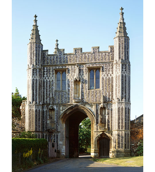 Exterior view of the turreted St johns Abbey Gate with its intricate decorative stonework and arched gateway, windows in the upper floor