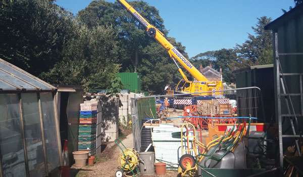 A crane moves construction equipment