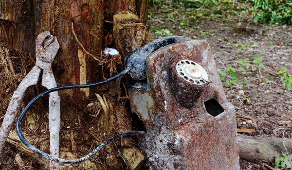 A rusted historic phone and shears A rusted historic phone and shears