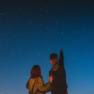 Two people looking up at a star-filled sky.
