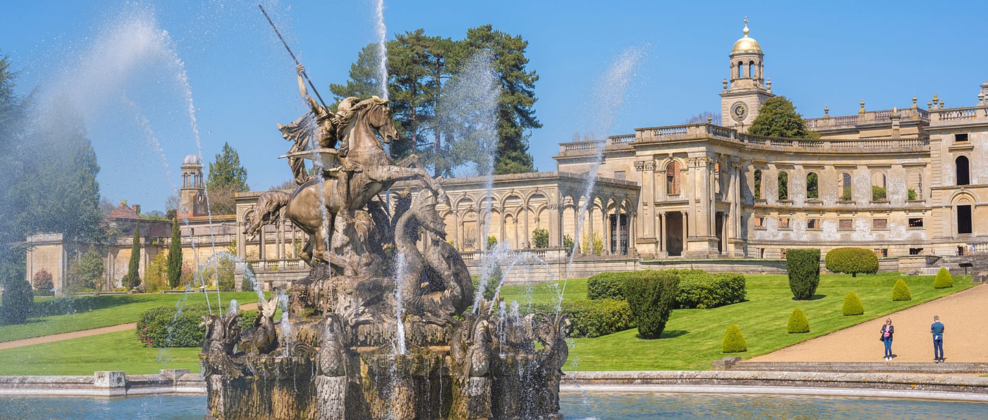 A view of the ruins of Witley Court with the fountain in the foreground.