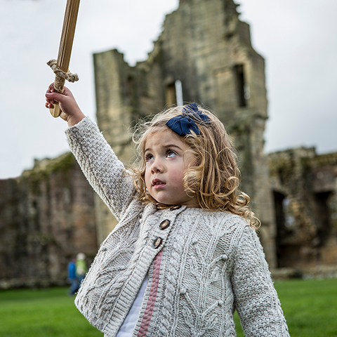 A girl holding a wooden sword high in the air. A girl holding a wooden sword high in the air.