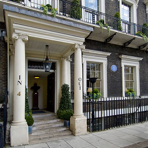 A grand town house with a blue plaque (to Nancy Astor) by the front door