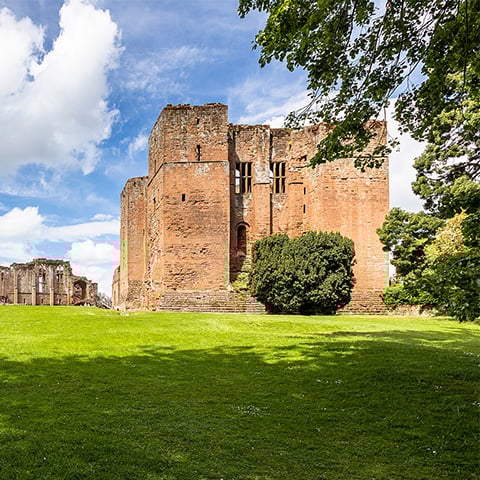 A view of the ruins of Kenilworth Castle on a sunny day.