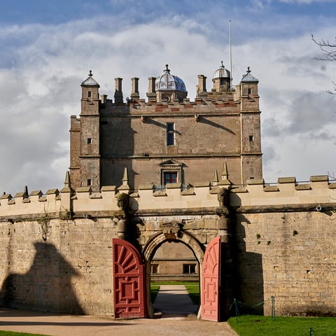 A view of Bolsover Castle with painted red open arched doors.
