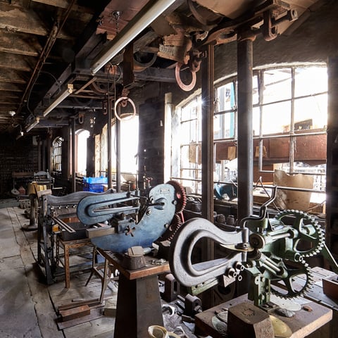 A view of a workshop in the J.W. Evans Silver factory with large windows.