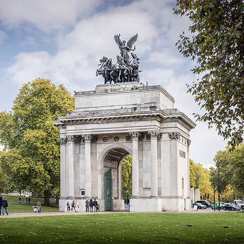 A grand white arch with a large statue on top