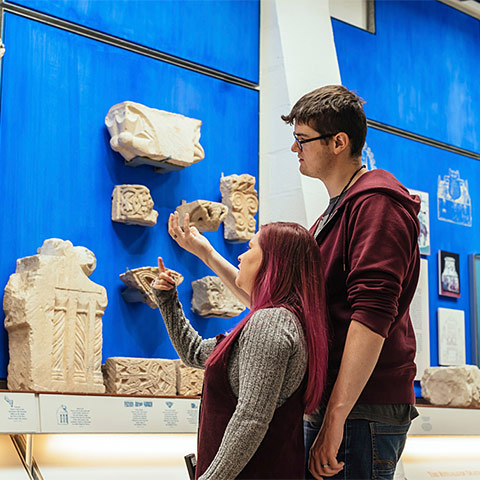 Two visitors engage with objects on display at St Augustine's Abbey