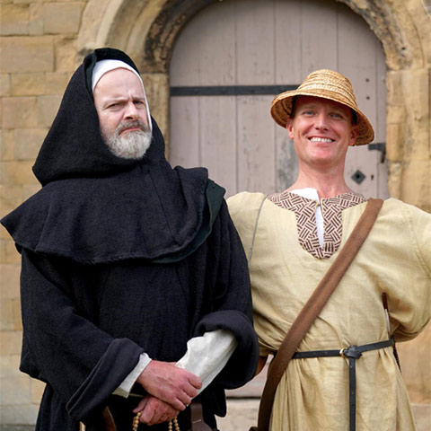 Two re-enactors dessed as a medieval monk and pilgrim
