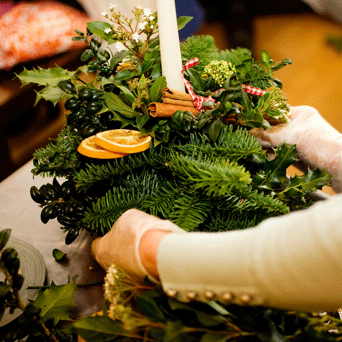 A close-up shot of someone making a Christmas table decoration