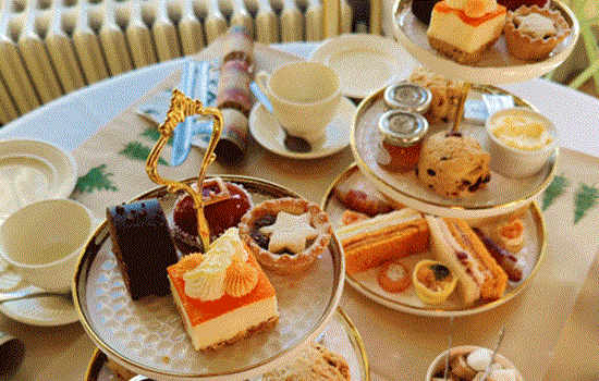 An Afternoon Tea set up with a selection of sandwiches and cakes on a table. An Afternoon Tea set up with a selection of sandwiches and cakes on a table.