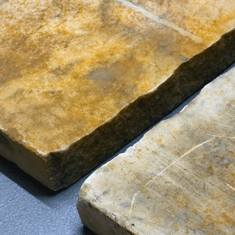 A close up photograph of two large cut stones laid flat on a blue background.