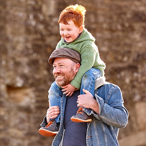 A man carries a young boy on his shoulders