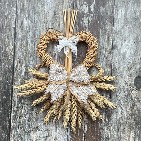 A decorative woven wheat wall hanging with two white lace bows.
