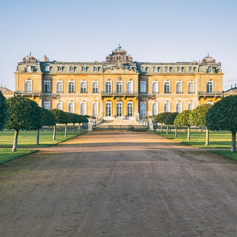 A view of the mansion of Wrest Park from a long straight pathway on a sunny frosty morning.