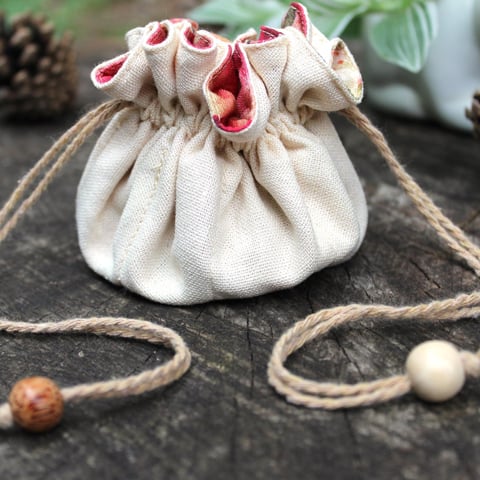 A small fabric bag with a woven string tie.