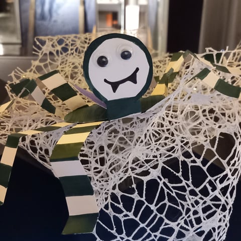 A close-up of a handmade paper spider halloween decoration.