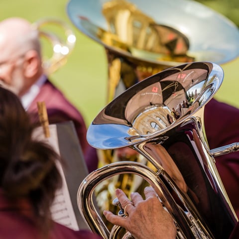 A close-up of people playing brass tubas.