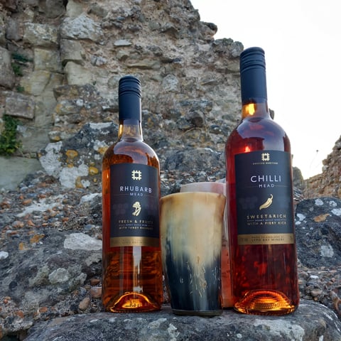 English Heritage wine bottles laid out on stone wall ruins.